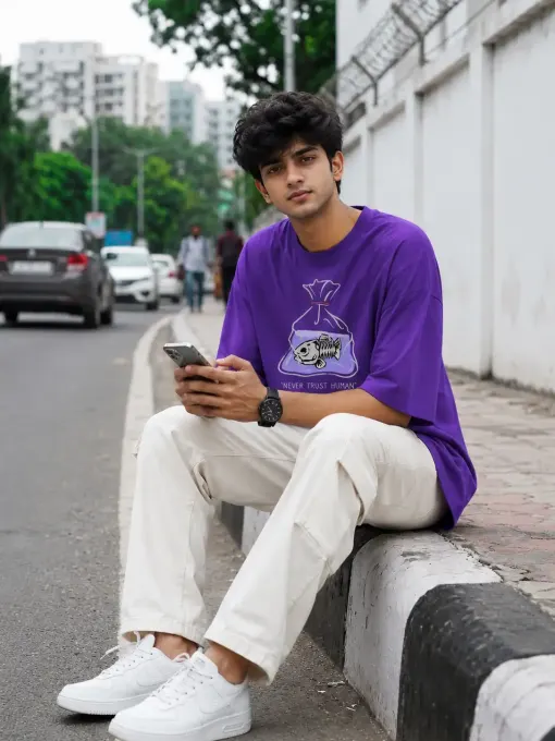 Model wearing an oversized 'Never Trust Human' graphic t-shirt in a relaxed streetwear fit